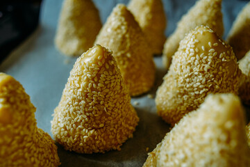 close up of a cake, bun with sesame seeds, pyramids, preparation in the kitchen