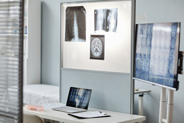 Fototapeta na wymiar No people shot of modern radiologists office interior with laptop, screen, x-ray and tomography images