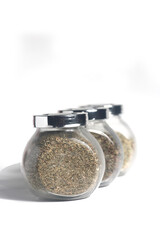 glass jars of paprica, fennel and oregano isolated on white background. Image contains copy space