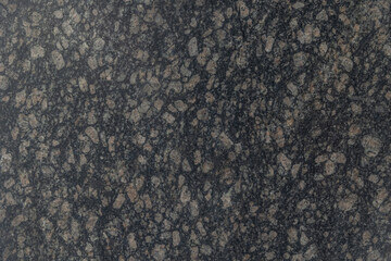 Texture black granite with small crystals and splashes. Background from a cut of stone, excellent visible structure