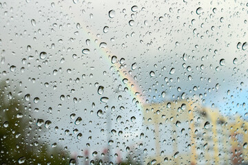 Drops of water on glass on background of rainbow
