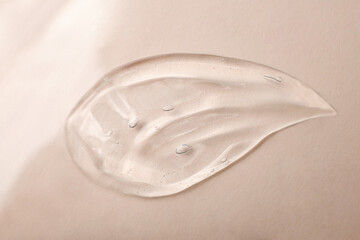 Top view of liquid cosmetics gel,looks like drop.Pastel beige background.Good as cosmetic mockup.