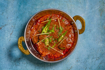 Spicyy mutton karahi masala with napkin isolated on wooden table top view of indian, pakistani food