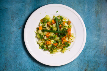 A plate of Special mixed green salad salad with cucumber, tomato, spring onion and green chilli isolated on background top view of healthy food dieting