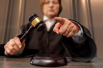 Judge banging judge's gavel, index finger pointing. Law Lord wearing gown using a hammer for...