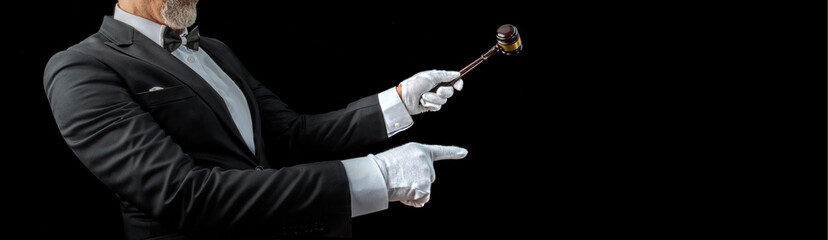 Auctioneer, salesperson with gavel at public auction. Senior male barker in formal elegant suit with auction hammer for close the bidding - obrazy, fototapety, plakaty