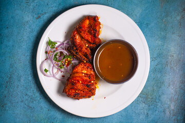 Chicken Bihari Tikka boti with chilli sauce and onion rings served in a plate top view of indian bbq fast food