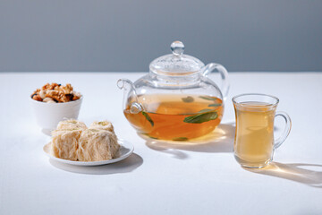Turkish tea and sweets, hot drink in traditional armudu glass close-up. National islamic pastry, treats.