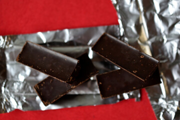 Chocolates on foil on a red background. Delicious candies.