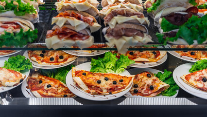 Glazed showcase inside a cafe with fresh Italian dishes and herbs in Milan, national Italian cuisine for fast food, close-up