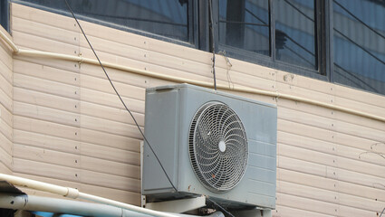 Air condition unit compressor or condensing unit installed outside building wall.Concept showing...