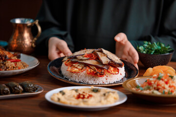Kabsa, hummus, maqluba, maqluba, tabbouleh close-up, rice and meat dish, middle eastern national traditional food. Muslim family dinner, Ramadan, iftar. Arabian cuisine.
