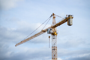 Construction site and yellow crane on the background blue sky