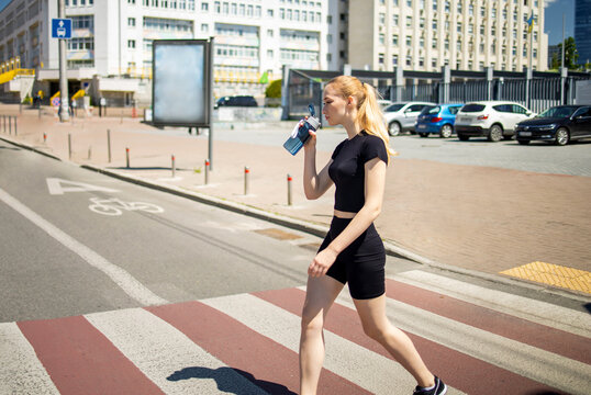 Fit woman crossing the road in city