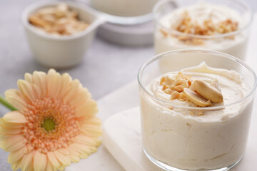 Creamy dairy yoghurt dessert with mascarpone, cream cheese and peanut butter in glasses on marble tray
