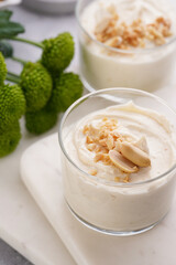 Creamy dairy yoghurt dessert with mascarpone, cream cheese and peanut butter in glasses on marble tray