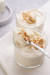 Creamy dairy yoghurt dessert with mascarpone, cream cheese and peanut butter in glasses on marble tray