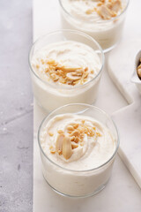 Creamy dairy yoghurt dessert with mascarpone, cream cheese and peanut butter in glasses on marble tray