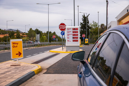 Blue car refuel at the Moreas Motorway-A7 on the background of a sign with prices on May 1, 2022 to ATHENS direction, Peloponnese, GREECE.