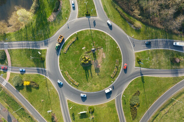 Aerial view of road roundabout intersection with moving heavy traffic. Urban circular...