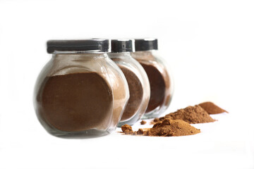 glass jars of paprica, chili and nutmeg isolated on white background. Image contains copy space