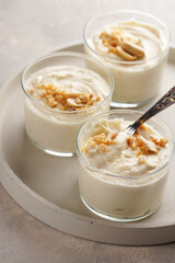 Creamy dairy yoghurt dessert with mascarpone, cream cheese and peanut butter in glasses on concrete...