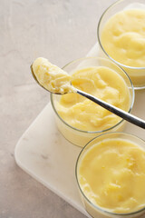 Creamy french vanilla pudding in glass on marble board on grey neutral background
