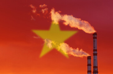 Against the background of the flag of Vietnam, smoke is emitted from the chimneys of the enterprise, polluting the air.