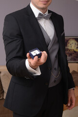 groom in suit with rings