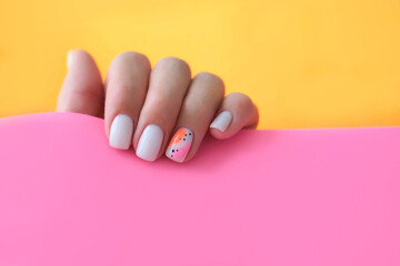 Beautiful female hands with a manicure on a pink and orange background. Shaded nail design. Summer manicure. Copy space.