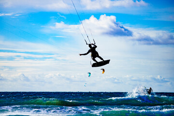 Kite surfer riding waves. Kiteboarding sport.