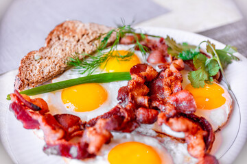 Tasty fried eggs eggs and crispy bacon, close-up, great classic breakfast. Macro photography, shallow depth of field.