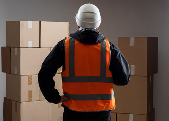 Builder with boxes. Male builder in back chamber. Concept of box with building materials....
