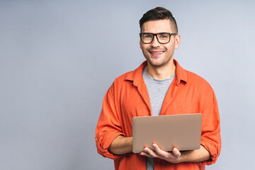 Confident business expert. Confident young handsome ukrainian man in casual holding laptop and...