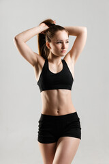 Fototapeta na wymiar Athletic girl with embossed abs in black sportswear