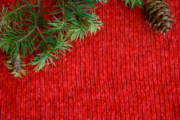 New Year or winter composition from a lush fir branch, cones on a red background. Background with place for text.