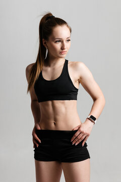 Athletic girl with embossed abs in black sportswear