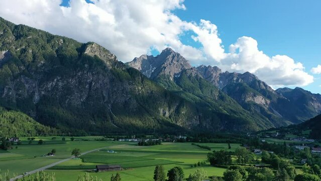 Long drone mountain view in the city of Lienz, Austria. Alpine mountains, clouds and sunlight over the city. Aerial view over the Austrian city in the mountains Alps	
