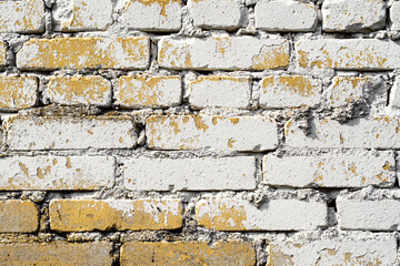 Old abstract brick white wall background with yellow paint stains. Grunge background texture