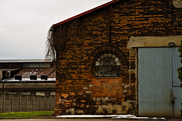 Stara przemysłowa budowla . Hala hutnicza zbudowana z czerwonej cegły , z łukowatymi oknami witrażowymi  . - obrazy, fototapety, plakaty