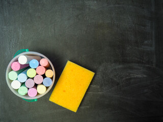 Empty blackboard with colored chalks and sponge copy space