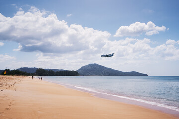 Airplane is landing near sea beach.