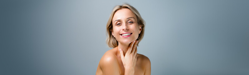 Natural beauty. Blonde woman with healthy skin.  No makeup. Grey background. Banner format.