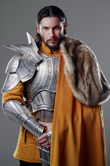 The King. Handsome Medieval knight in armor and yellow cloak.