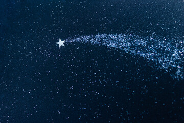 Confetti applique on dark blue glitter of cardboard. Shooting star and stardust. Concept of dream...
