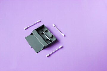 Reusable (long-lasting) silicone ear sticks on purple background. Alternative to disposable cotton swabs. Zero waste concept. Reduce waste, save money, save planet. Copy space, top view, horizontal 