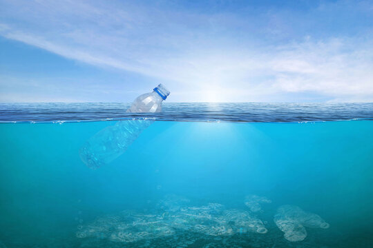 Creative background, plastic bottle floating in the ocean, a bottle in the water.