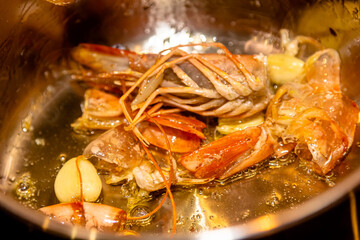 Tasty appetizing roasted shrimps prawns with spices on pan with ingredients on black background. Top View with Copy space. Food Background Italian Kitchen Concept.