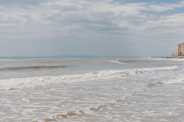 Seascape. Foam waves at sandy beach. Waterscape for background. Nature concept. Soft focus. Motion waves. Copy space.
