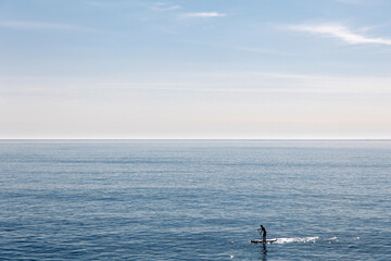 Young man floating on a SUP board. The adventure of the sea with blue water on a surfing.